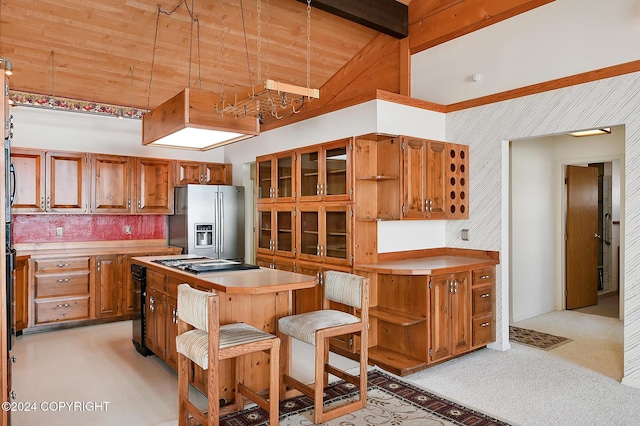 2795 Watergate Way, Kenai, AK 99611 - kitchen featuring stainless steel refrigerator with ice dispenser, light colored carpet, stovetop, brown cabinetry, and high vaulted ceiling