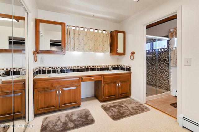 bathroom featuring vanity, decorative backsplash, a shower with door, and a baseboard radiator