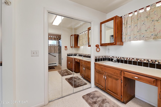 2795 Watergate Way, Kenai, AK 99611 - bathroom featuring a baseboard heating unit, vanity, tasteful backsplash, and speckled floor