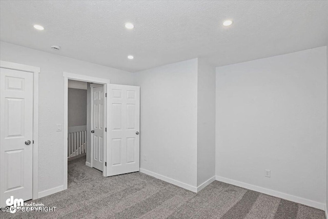 unfurnished bedroom with light colored carpet and a textured ceiling