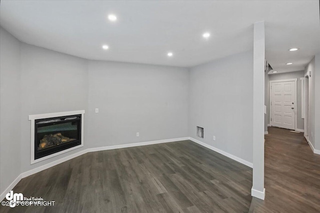 unfurnished living room with dark wood-type flooring