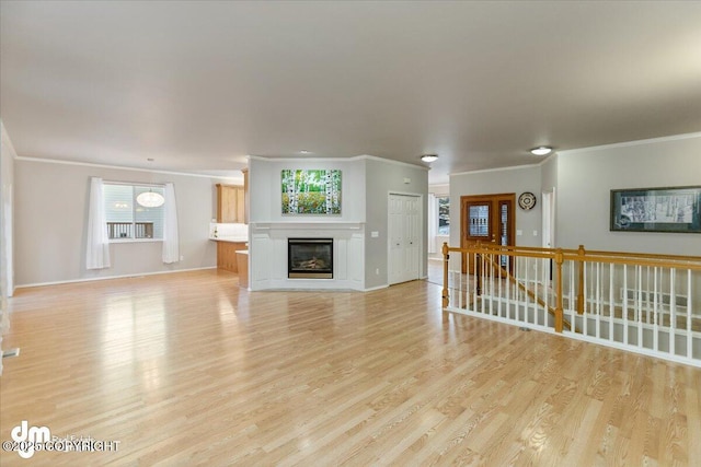 unfurnished living room featuring light hardwood / wood-style flooring and ornamental molding