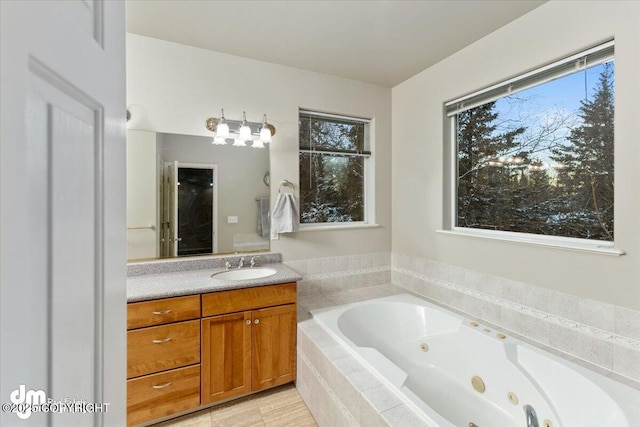 bathroom featuring vanity, tile patterned flooring, and a relaxing tiled tub