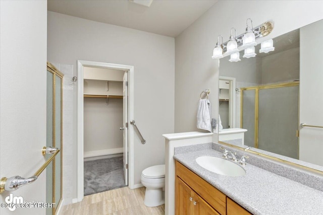 bathroom featuring vanity, toilet, and walk in shower