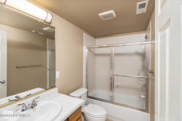 full bathroom with toilet, vanity, a textured ceiling, and combined bath / shower with glass door