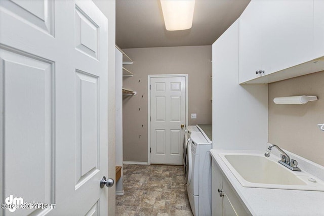 washroom featuring separate washer and dryer, sink, and cabinets