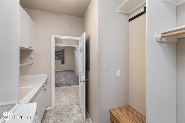 clothes washing area with cabinets