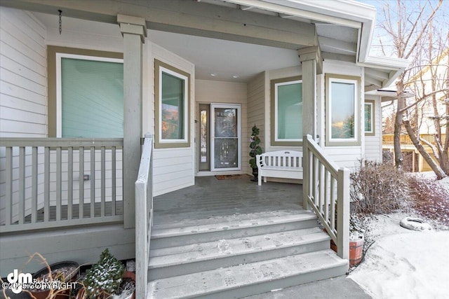 view of exterior entry featuring covered porch