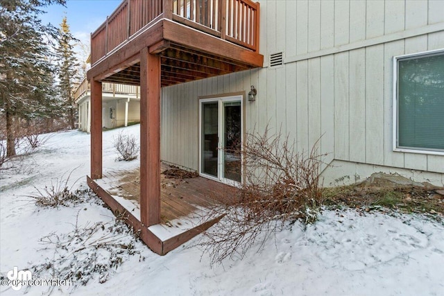 view of snowy exterior with a deck