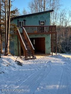 snow covered back of property featuring a deck