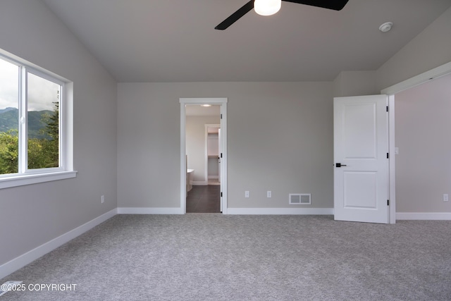 unfurnished bedroom featuring connected bathroom, ceiling fan, carpet, and lofted ceiling