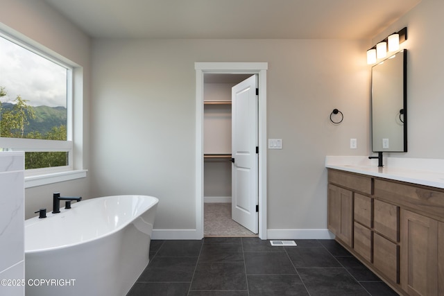 bathroom featuring tile patterned flooring, vanity, and a tub