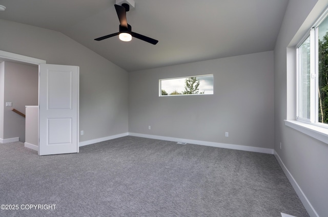 carpeted empty room featuring ceiling fan, a healthy amount of sunlight, and vaulted ceiling