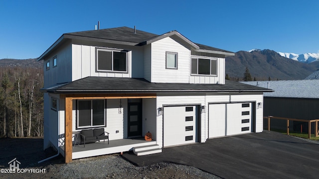 view of front of home featuring a mountain view, covered porch, and a garage