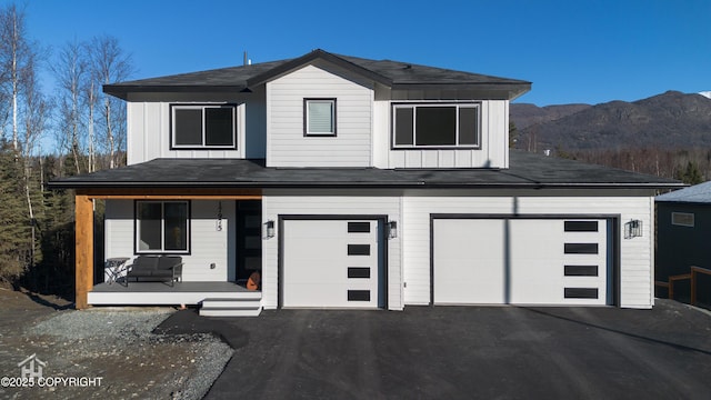 view of front of property with a mountain view, a garage, and covered porch