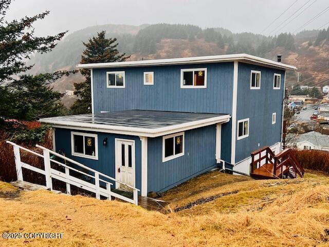 rear view of house featuring a mountain view