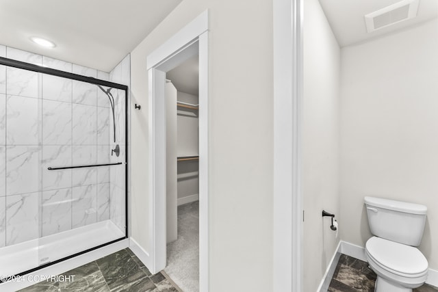 bathroom featuring toilet and an enclosed shower