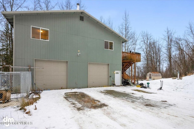 snow covered rear of property with a deck