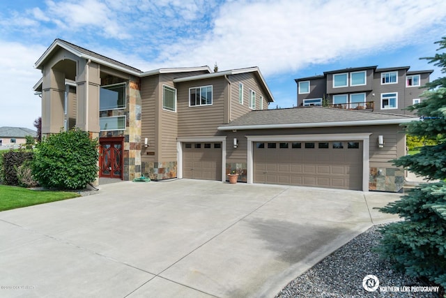 16643 Woods Pointe Cir, Anchorage, AK 99516 - view of front of home featuring stone siding, concrete driveway, and a garage