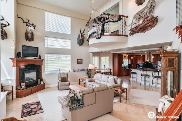 16643 Woods Pointe Cir, Anchorage, AK 99516 - living area featuring a towering ceiling, a fireplace, and light tile patterned floors