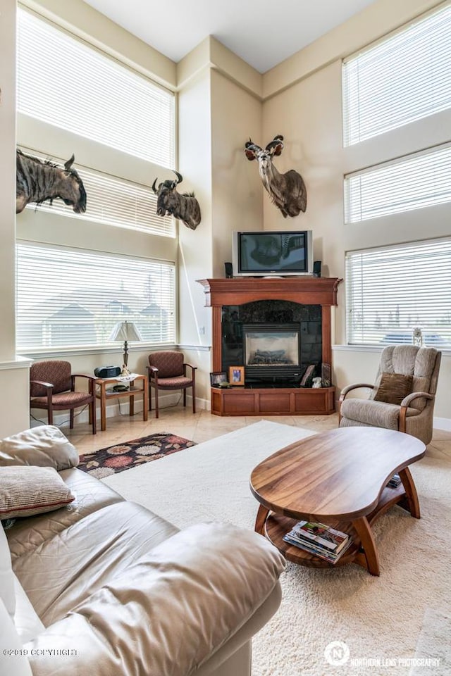 16643 Woods Pointe Cir, Anchorage, AK 99516 - living area featuring healthy amount of natural light, a tiled fireplace, and a high ceiling