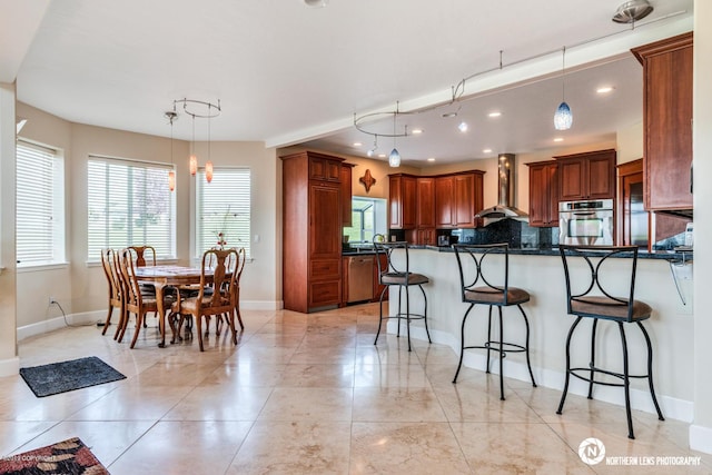 16643 Woods Pointe Cir, Anchorage, AK 99516 - kitchen with stainless steel appliances, wall chimney range hood, a breakfast bar, dark countertops, and a peninsula