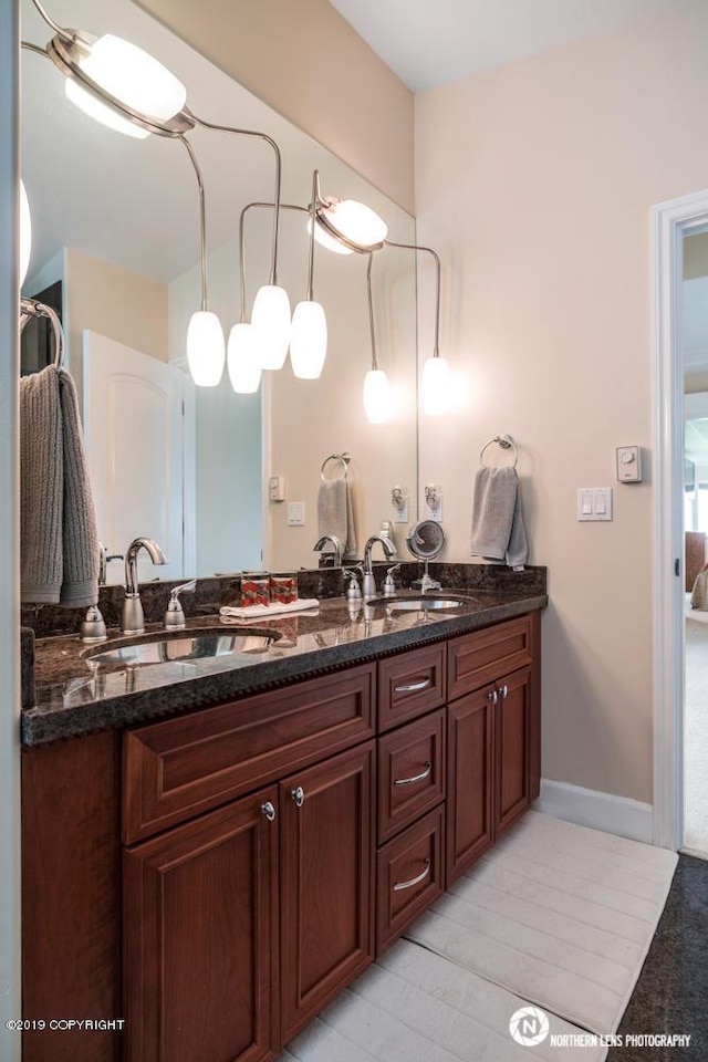 16643 Woods Pointe Cir, Anchorage, AK 99516 - ensuite bathroom with double vanity and baseboards