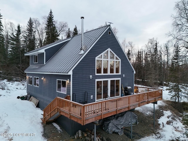 snow covered property with a wooden deck