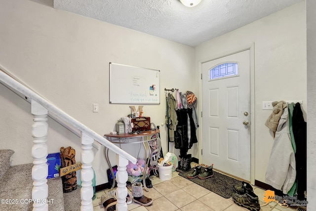 foyer with light tile patterned floors and a textured ceiling