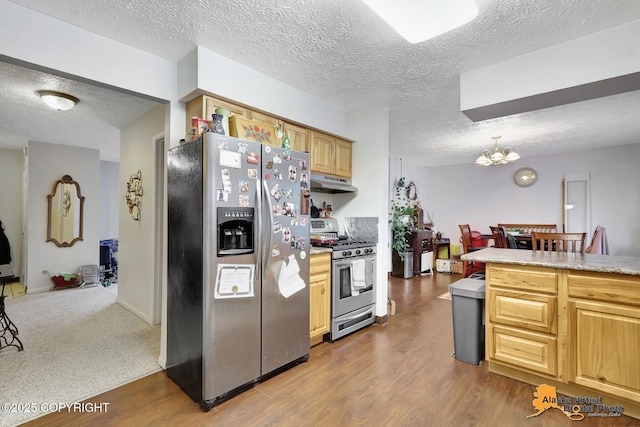 kitchen featuring a chandelier, appliances with stainless steel finishes, a textured ceiling, and wood-type flooring