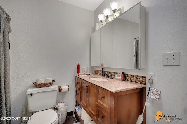 bathroom featuring decorative backsplash, toilet, and vanity