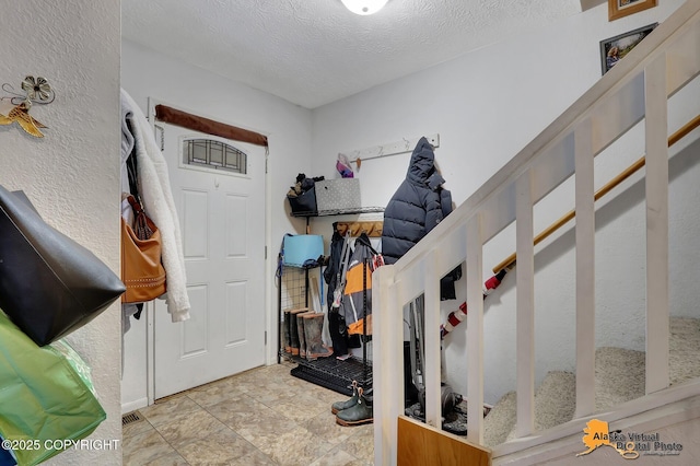 mudroom with a textured ceiling