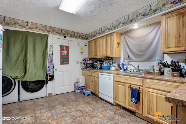 kitchen with a textured ceiling, sink, light brown cabinets, separate washer and dryer, and dishwasher