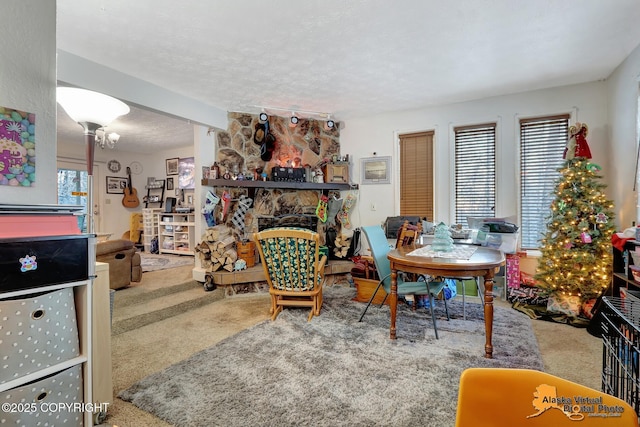 carpeted living room with a stone fireplace and a textured ceiling