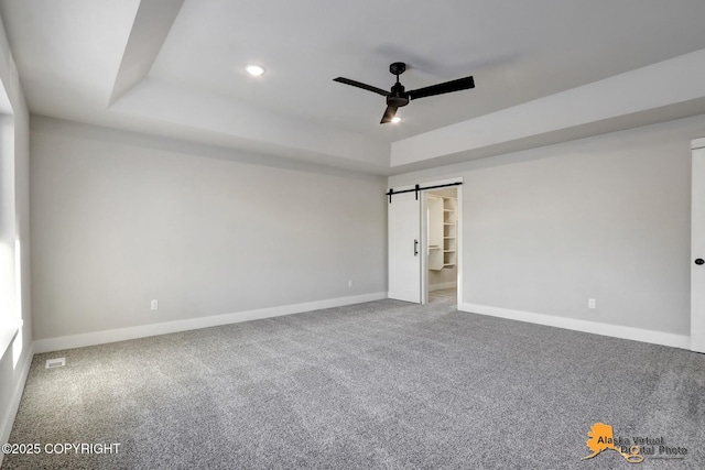 8803 Chalk Hill Loop, Anchorage, AK 99502 - spare room featuring a raised ceiling, a barn door, a ceiling fan, carpet floors, and recessed lighting