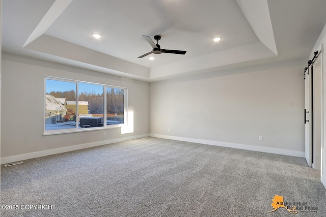 8803 Chalk Hill Loop, Anchorage, AK 99502 - carpeted spare room with a raised ceiling, a barn door, a ceiling fan, and recessed lighting