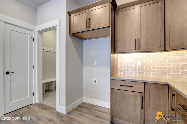 8803 Chalk Hill Loop, Anchorage, AK 99502 - kitchen with light wood-style flooring, backsplash, and light countertops