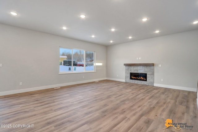 8803 Chalk Hill Loop, Anchorage, AK 99502 - unfurnished living room with wood finished floors, recessed lighting, and a tiled fireplace