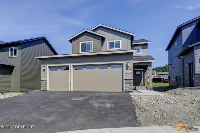8803 Chalk Hill Loop, Anchorage, AK 99502 - craftsman-style home featuring stone siding, driveway, board and batten siding, and an attached garage