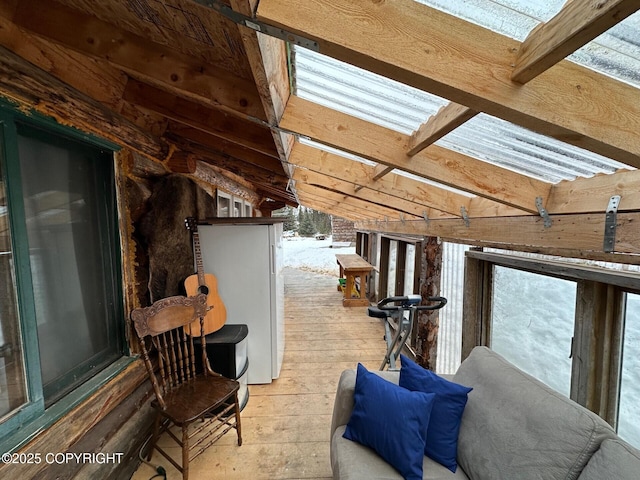 interior space featuring hardwood / wood-style flooring and lofted ceiling with beams