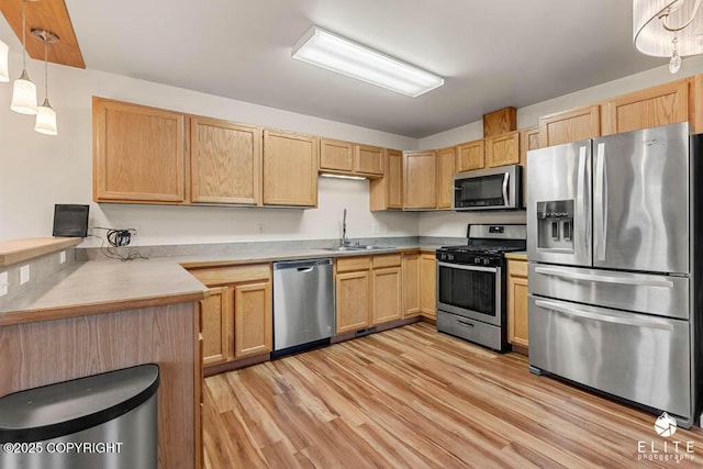 kitchen with light brown cabinetry, sink, pendant lighting, and appliances with stainless steel finishes