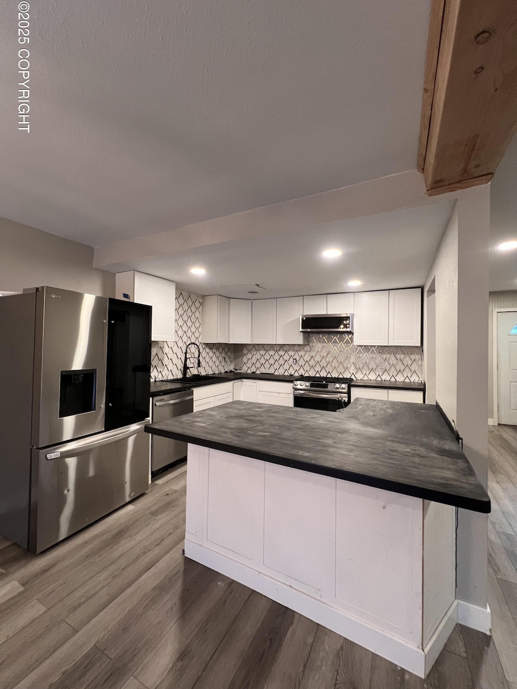 kitchen featuring kitchen peninsula, extractor fan, dark hardwood / wood-style floors, stainless steel appliances, and white cabinets