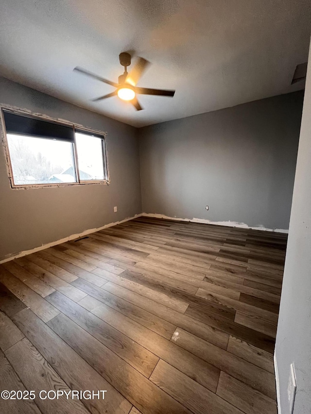 empty room featuring ceiling fan and hardwood / wood-style floors