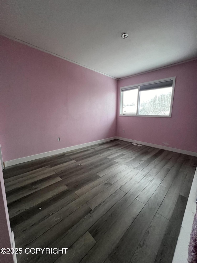 spare room with crown molding and dark hardwood / wood-style floors