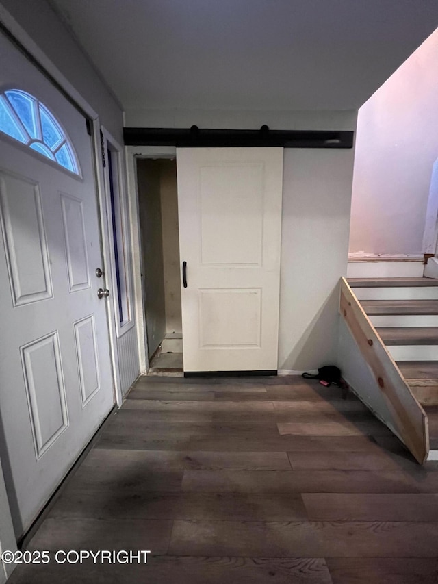 corridor featuring dark wood-type flooring and a barn door