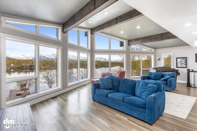 sunroom / solarium with a water view and lofted ceiling with beams