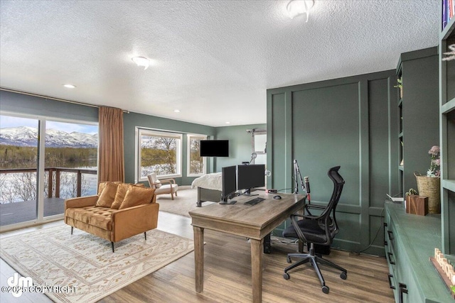 office with light hardwood / wood-style flooring and a textured ceiling