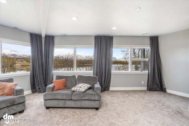 carpeted living room featuring a healthy amount of sunlight and a water view