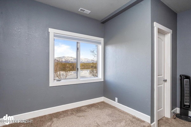 spare room featuring carpet and a mountain view