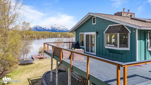 exterior space with a deck with water view and a yard